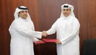 Acting Assistant Undersecretary for Shared Services Affairs at MoEHE, Ali Abdullah Al Buainain and CEO of WISA Abdulhadi Bakhit Burgan exchanging documents after singing the agreement.