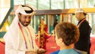 Abdulla Al Qahtani at a World Cup stadium interacting with a child.