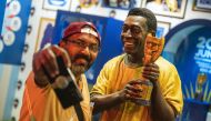 A fan poses for a selfie photograph with a statue of the Brazilian football legend Pele in Doha on December 6, 2022, during the Qatar 2022 World Cup football tournament. (Photo by ANDREJ ISAKOVIC / AFP)