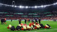 Morocco players and coaching celebrate winning the penalty shootout as Morocco progress to the quarter finals of the FIFA World Cup Qatar 2022 at the Education City Stadium, Al Rayyan, Qatar, on December 6, 2022.  REUTERS/Matthew Childs