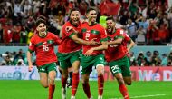 Morocco's defender Achraf Hakimi (centre) celebrates with teammates after converting the last penalty during the penalty shoot-out to win the Qatar 2022 World Cup round of 16 match between against Spain at the Education City Stadium in Al-Rayyan, west of Doha, on December 6, 2022. (Photo by JAVIER SORIANO / AFP)