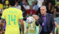 Brazil's coach Tite throws the ball to Brazil's Eder Militao during the Qatar 2022 World Cup quarter-final football match between Croatia and Brazil at Education City Stadium on December 9, 2022. (Photo by JACK GUEZ / AFP)