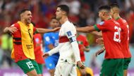 Portugal's Cristiano Ronaldo looks dejected after being eliminated from the World Cup as Morocco players celebrate after progressing  into the semi finals at the Al Thumama Stadium, Doha, Qatar, on December 10, 2022.  REUTERS/Carl Recine 