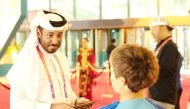 Abdulla Al Qahtani interacting with a child at a World Cup stadium.