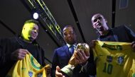 Brazilian former footballers and World Cup winners, Ronaldo Nazario (left), Cafu (centre) and Rivaldo, are seen next to the World Cup trophy during a ceremony organized by the Brazilian Football Confederation (CBF) to celebrate the 20th anniversary of the fifth World Cup title obtained by the national team in the 2002 FIFA Korea/Japan tournament, at the Fairmont Hotel in Rio de Janeiro, Brazil, on June 30, 2022. File Photo / AFP