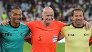 FIFA President Gianni Infantino (centre) wearing a referee uniform poses with former Brazilian footballer Cafu (left) and former Italian footballer Alessandro Del Piero as he officiates the friendly match of FIFA Legends and Qatar-based workers at Al Thumama Stadium in Doha on December 12, 2022. (Photo by KARIM JAAFAR / AFP)
 