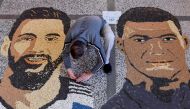 Kosovar artist Alkent Pozhegu works on the last details of his mosaic, made with grain and seeds on the ground, depicting Argentina's forward Lionel Messi (left) and France's forward Kylian Mbappe in the town of Gjakova on December 17, 2022, on the eve of the Qatar 2022 World Cup final match between Argentina and France. (Photo by Armend NIMANI / AFP) 