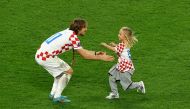 Luka Modric wears his medal as he celebrates with his daughter on the pitch after Croatia finished in third place.