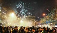 Fireworks explode overhead as people gather on the Champs-Elysees after the final football match of the Qatar 2022 World Cup between Argentina and France in central Paris on December 18, 2022. (Photo by Charly Triballeau / AFP)
 