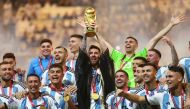 Argentina’s captain Lionel Messi lifts the World Cup trophy alongside teammates at Lusail Stadium on Sunday. REUTERS