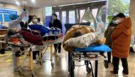 Covid-19 patients on stretchers in the emergency ward of the First Affiliated Hospital of Chongqing Medical University in China's southwestern city of Chongqing on December 22, 2022. (Photo by Noel Celis / AFP)