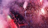 Morocco players are pictured on a bus as their fans celebrate with flares during a parade as the team return from Qatar. REUTERS