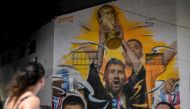 A mural by artist Maxi Bagnasco depicting Argentina's captain and forward Lionel Messi raising the FIFA World Cup Trophy next to his teammates after winning the Qatar 2022 World Cup tournament is seen in Buenos Aires on December 22, 2022. (Photo by Luis ROBAYO / AFP) 