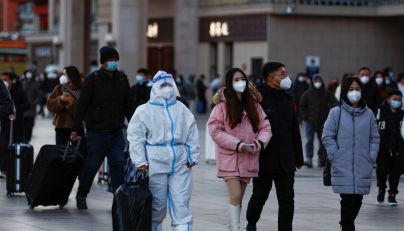 A traveller wearing a protective suit walks outside Beijing Railway Station as the annual Spring Festival travel rush starts, amid the coronavirus disease (COVID-19), ahead of the Chinese Lunar New Year, in Beijing, China, on January 7, 2023. REUTERS/Tingshu Wang