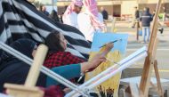 Artists work on their paintings, as part of Halal Qatar Festival being held at Katara Cultural Village. 