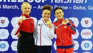 The medal winners of the women’s vault final celebrate on the podium.