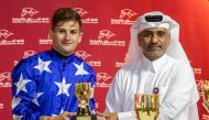 Al Uqda Complex Manager Abdulaziz Jassim Al Boenain presents trophy to Lukas Delozier. 