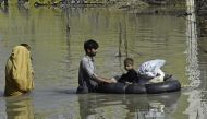 A family wades through a flood hit area following heavy monsoon rains in Charsadda district of Khyber Pakhtunkhwa on August 29, 2022.  File photo / AFP
