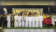 Qatar SC players and officials celebrate with the champions trophy.