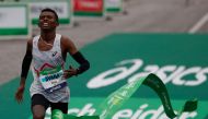 Ethiopia's Abeje Ayana crosses the finish line to win the 2023 Paris Marathon, at the Arc de Triomphe in Paris on April 2, 2023. Photo by Geoffroy Van der Hasselt / AFP