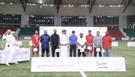 Minister of Sports and Youth H E Salah bin Ghanim Al Ali (centre) with players and referees after the final. 