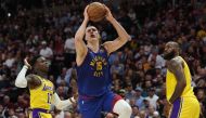 Nikola Jokic #15 of the Denver Nuggets shoots the ball between Dennis Schroder #17 and LeBron James #6 of the Los Angeles Lakers during the third quarter in game one of the Western Conference Finals at Ball Arena on May 16, 2023 in Denver, Colorado. Matthew Stockman/Getty Images/AFP 