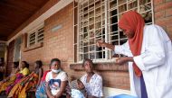 A clinician at Ndirande Health Centre demonstrates to clients how to take the cholera vaccine in response to the latest cholera outbreak in Blantyre, Malawi, November 16, 2022. (REUTERS/Eldson Chagara)