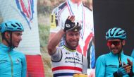 Astana Qazaqstan Team's British rider Mark Cavendish (C), holding a cake to celebrate his 38th birthday, waves during the presentation of the teams prior to the fifteenth stage of the Giro d'Italia 2023 cycling race, 195 km between Seregno and Bergamo, on May 21, 2023. Photo by Luca Bettini / AFP