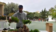 In this picture taken on May 19, 2023, farmer Saber Zouani arranges his organic vegetables to sell at the French primary school in Bizerte, grown using permaculture, a natural technique that is beginning to gain a foothold in Tunisia as a solution to climate challenges. Photos by FETHI BELAID / AFP