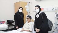 Qatar Cancer Society representatives with a cancer survivor. 