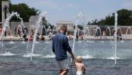 
Visitors and tourists to the World War II Memorial seek relief from the hot weather in the memorial's fountain on July 3, 2023 in Washington, DC. (Photo by Kevin Dietsch/Getty Images via AFP)