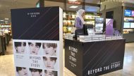 A woman looks at copies of the BTS memoir titled 