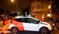 Members of SafeStreetRebel, a group of anonymous anti-car activists, place a cone on a self-driving robotaxi to disable it in San Francisco, California on July 11, 2023. Photo by Josh Edelson / AFP