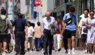 Pedestrians walk during heatwave conditions in Tokyo on July 18, 2023. (Photo by Kazuhiro NOGI / AFP)