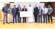 Shaijan MO, Regional Director of Lulu Group, presenting a donation of QR100,000 to Mohammad Faisal, Executive Director of the Qatari Autism Society. 