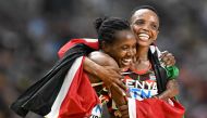 Kenya's Faith Kipyegon (L) and Beatrice Chebet celebrate while draped in their national flag after the women's 5000m final during the World Athletics Championships at the National Athletics Centre in Budapest on August 26, 2023. (Photo by Jewel SAMAD / AFP)
