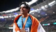 Gold medalist, India's Neeraj Chopra celebrates with his National flag and medal after the men's javelin throw final during the World Athletics Championships at the National Athletics Centre in Budapest on August 27, 2023. (Photo by Kirill Kudryavtsev / AFP)