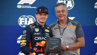 Red Bull Racing's Dutch driver Max Verstappen (L) poses with Pirelli F1 boss Mario Isola after taking the poll position. (Photo by Peter PARKS / AFP)