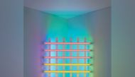 Dan Flavin, untitled (in honour of Harold Joachim) 3 (1977).__Pink, yellow, blue, and green fluorescent light, 8 ft. (244cm) square across a corner. The Dan Flavin Estate, Courtesy David Zwirner. © 2023 Stephen Flavin / Artists Rights Society (ARS), New York. Photo: Courtesy David Zwirner.
