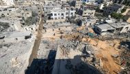 Palestinians gather to search for survivors in rubble of a collapsed building following an Israeli strike, in Khan Yunis in the southern Gaza Strip on October 14, 2023. (Photo by Mahmud Hams / AFP)