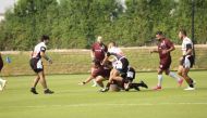 A Qatar player is being tackled by Jordan players during their match on Day 1 of the Asia Rugby Sevens Trophy tournament.