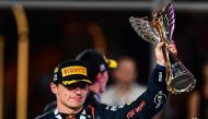 Red Bull Racing's Dutch driver Max Verstappen celebrates on the podium with the trophy after winning the Abu Dhabi Formula One Grand Prix at the Yas Marina Circuit in the Emirati city on November 26, 2023. (Photo by Jewel SAMAD / AFP)
