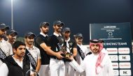 Team NK Cafe members Hussain Saeed Haidan, Ghanim Nasser Al Qadi and Saeed Nasser Al Qadi receive their trophy during the podium ceremony.