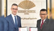 General Manager of Mandarin Oriental, Doha, Thomas Kinsperger (left) and another official with the ISO certification.