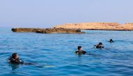 Volunteer divers remove fishing nets from coral reefs at Oman's Dimaniyat islands on October 4, 2024. (Photo by Karim Sahib / AFP)