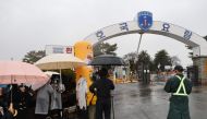 A South Korean soldier (R) stands as reporters and BTS fans gather in front of the main gate of a military boot camp in Nonsan on December 11, 2023, where BTS members RM and V are scheduled to arrive to begin their military service. Photo by YONHAP / AFP