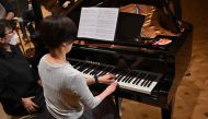 This picture taken on December 20, 2023 shows Hiroko Higashino (C) playing an AI-powered piano during a Christmas concert rehearsal of Beethoven Symphony No 9 with the Yokohama Sinfonietta orchestra in Tokyo. (Photo by Kazuhiro Nogi / AFP)
 