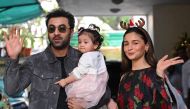 Bollywood actors Ranbir Kapoor (L) and his wife Alia Bhatt pose with their daughter Raha upon their arrival for a Christmas brunch in Mumbai on December 25, 2023. (Photo by Sujit Jaiswal / AFP)
