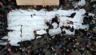 An aerial view shows Palestinians mourning their relatives, killed in an overnight Israeli strike on the Al-Maghazi refugee camp, during a mass funeral at the Al-Aqsa hospital in Deir Al-Balah, in the southern Gaza Strip, on December 25, 2023. Photo by MAHMUD HAMS / AFP