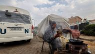 A displaced Palestinian woman lights a cooking fire outside a tent in Rafah in the southern Gaza Strip on December 27, 2023. (Photo by Mohammed Abed / AFP)
